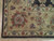Corner detail of gold border with rose palmettes, ivory fringe and dark charcoal outer edge