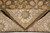 Folded corner revealing even hand-knotted back, border motifs and dark brown edge binding