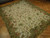 Angled floor view showing cream field, green palmette leaves and rust flowers across the all over design