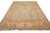 6'10" x 11'4" hand-knotted Oushak rug angled view showing wide sandy border and fringe