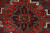 Detail of the central geometric medallion in brick red, indigo and olive hand-knotted wool pile