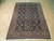6'9" x 9'10" Persian Sarouk rug displayed flat on light hardwood floor, fringe forward