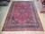 Full overhead view of 9'9" x 13'3" Persian Tabriz rug, red field, navy medallion, ivory fringe