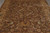 Close field view of hand-knotted wool rug with golden vine scroll and burgundy rosettes