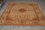 8x10 Indian Agra rug laid on grey tile showroom floor, ivory ground, wide floral border