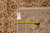 Rug back with inventory tag reading 8.2 x 9.9 beside a yellow measuring tape