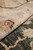 Macro of beige border pile with rose and black floral sprig, soft wool texture