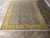 Hand-knotted wool Oushak design rug laid flat on showroom tile floor, full view