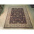 Multi-colored 8x10 wool area rug shown full length on showroom hardwood floor