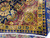 Folded corner showing dense hand-knotted back, cotton fringe and burgundy border with gold rosette