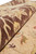 Rolled edge close-up showing dense natural wool pile in brown, gold and beige tones
