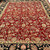 Deep red wool field covered in ivory, gold and green blossoms photographed outdoors