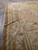 Side border detail showing fluted column motif, floral garlands and fold crease across the flat weave