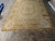 Neutral 9x14 Aubusson rug laid out in the warehouse, oval medallion centred on golden beige field