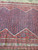 Rose red end panel with turquoise rosettes framing the indigo boteh medallion of this antique runner