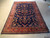 6'6" x 9'10" Indian hand-knotted wool rug laid flat on a concrete showroom floor