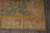 Corner detail showing gold lotus border, zigzag guard stripes and ivory fringe of the wool rug
