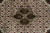 Macro detail of medallion center showing olive, rust and slate blue fish motifs in wool