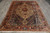 Hand-knotted wool Bakhtiar rug photographed flat on grey tile with ivory fringe at both ends