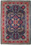 Flat overhead view of navy blue Persian Sarouk rug with red floral border and rosette medallion