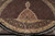 Close view of ivory pendant medallion tip, black main border scrollwork and hand-tied fringe edge
