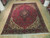 9'8" x 12'10" Persian Tabriz rug laid flat on light wood showroom floor, full pattern