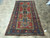 5' x 10'2" Kazak gallery size rug displayed flat on travertine tile showroom floor