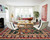 White living room furnished with the green Kazak rug, cream sofa, chairs and wood coffee table