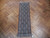 Runner laid flat on herringbone parquet floor, dark field reading almost solid from standing height