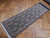 Angled view along the runner showing diamond compartments, rose rosettes and white cotton fringe at one end