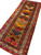 Opposite-end angled view with fringe in the foreground and saffron and burgundy diamonds receding