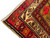 Corner detail of the ivory fringe, red border chain and brown selvedge along the short end