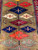 Overhead detail of paired navy, ivory and orange medallions linked by the dark central stem
