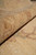 8x11 Chobi Peshawar rug rolled back to reveal low pile and hand-spun wool texture