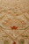 Angled macro of beige field meeting inner border with rust red star flower motif