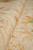 Rolled edge revealing dense wool pile depth, ivory ground and soft gold vine drawing