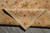 Folded corner showing tight cotton foundation weave, hand-tied fringe and beige border reverse