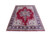 Angled studio shot showing red Tabriz medallion rug with ivory corners and indigo main border