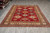 7 by 10 Kazak area rug displayed on grey tile floor in the Freeport showroom