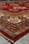 Low angle along the rug edge showing layered borders, navy rosettes and clean red selvage