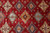 Center field close-up with ivory, navy and sky blue diamond medallions on ruby red ground