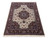 8'2" x 10' hand-knotted wool rug photographed at an angle with ivory field and brown floral border
