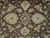 Close-up of ivory rosettes, serrated leaves and vine scrolls on the chocolate brown field