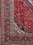 Corner detail with indigo palmette border, powder blue guard stripes and ivory floral spandrel