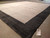 Angled floor view with inventory tag for rug number 5449 beside charcoal border