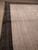 Dark charcoal border framing an abrash striped silver field, seen from the corner