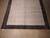 Contemporary Indian wool rug photographed lengthwise, pale gray center panel inside charcoal frame
