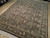 8x10 Chinese Oriental rug angled on showroom floor, grapevine borders and ivory fringe visible