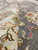 Detail of folded ivory border beside gray field showing hand-knotted wool depth and clean clip
