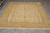 Hand-knotted Peshawar wool rug photographed flat on grey tile floor with ivory cotton fringe